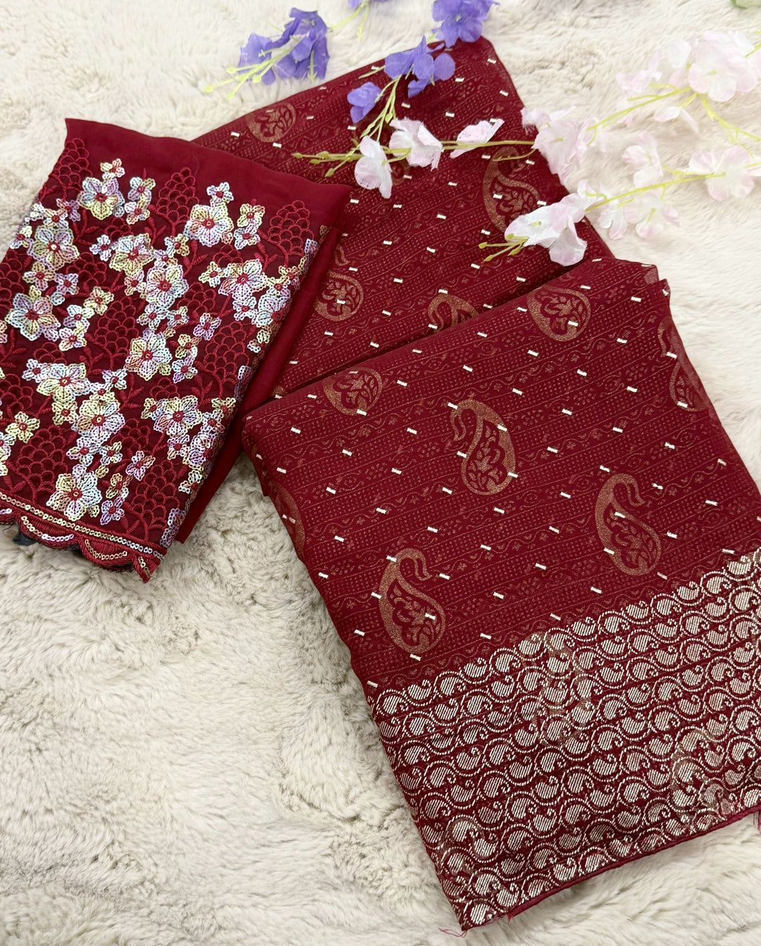 deep maroon shade with golden zari work and multi-coloured floral embroidery on the blouse piece.







